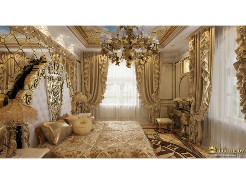 спальня в дворцовом стиле: много драпировок, расписной потолок, люстра в стиле ампир. Изголовье кровати украшено резьбой и зеркалом. 