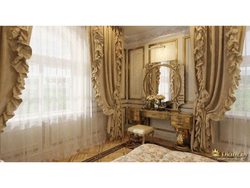 туалетный столик в дворцовом стиле: круглое зеркало, молдинги, позолота и окна, задрапированные бежевыми шторами с подхватами и рюшами